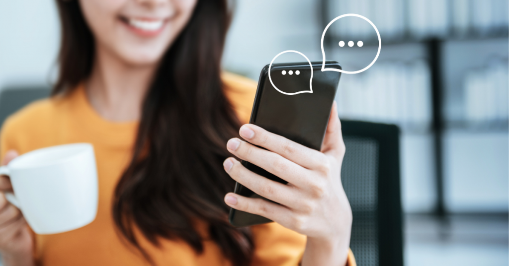 person smiling at phone holding coffee cup, live chat message bubbles, speech bubbles, live chat service