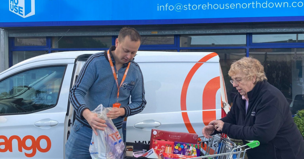 mango van outside storehouse north down  - man giving trolley full of food to foodbank - sustainable initiative